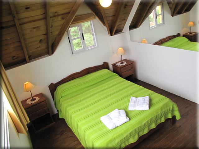 Dormitorio principal de la cabaña de 3 ambientes, con techo de madera a dos aguas