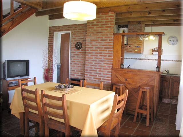 Comedor con mesa y cocina al fondo