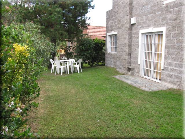 Parque con mesa y sillas de jardín junto a la casa