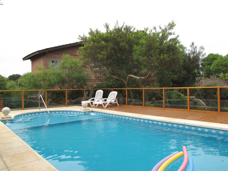 Solárium con reposeras junto a la piscina